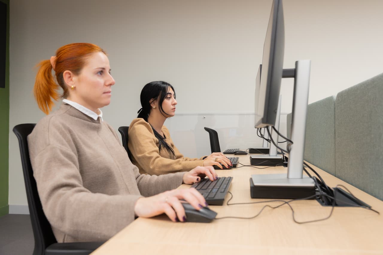 2 employees working at a desk with a computer