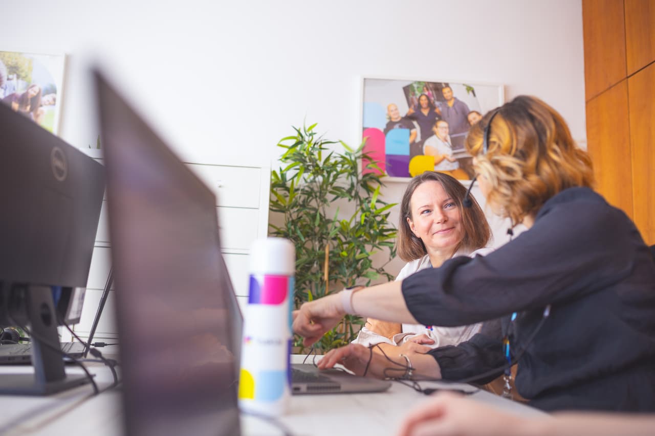 2 employees working at a desk with a computer